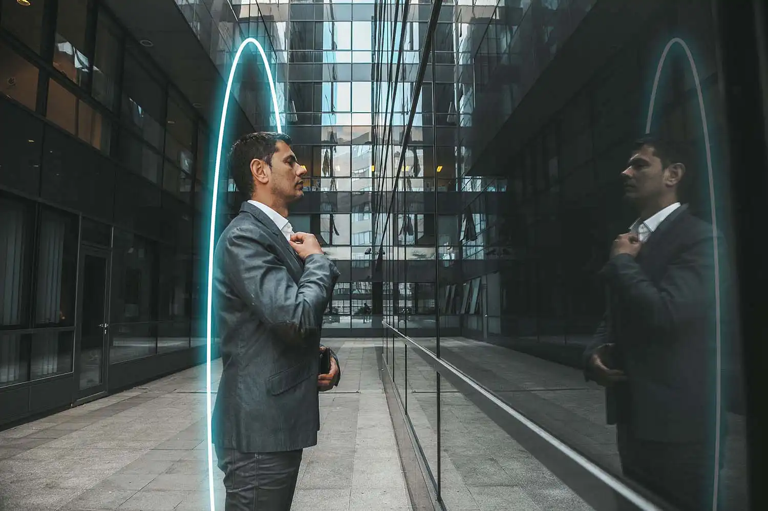Man kijkt in weerspiegeling van gebouw en denkt na over het verkoopproces van zijn bedrijf